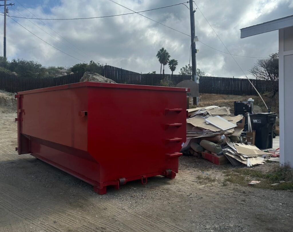 Red dumpster near construction debris.